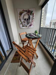 a small balcony with a table and two chairs at Studio SP ao lado Shopping Frei Caneca in São Paulo