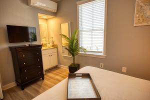 1 dormitorio con 1 cama, vestidor y TV en Inn on Main Annapolis en Annapolis