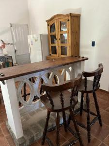 cocina con mesa de madera y 2 sillas en La Escondida, en Aguas Dulces