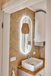 La salle de bains est pourvue d'un lavabo et d'un miroir. dans l'établissement Wood House Trzęsacz, à Trzęsacz