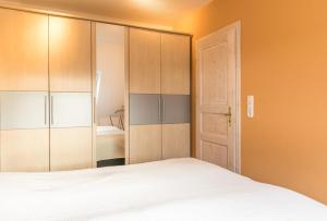 1 dormitorio con 1 cama y puerta abierta en "Haus am Teich" Haus am Teich, Whg 2, en Büsum