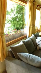 eine Couch mit Kissen vor einem Fenster in der Unterkunft Cabañas Gnionguis in Villa La Angostura