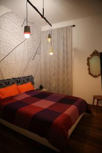 een slaapkamer met een bed, 2 verlichting en een spiegel bij Alloggio incantevole in trastevere in Rome