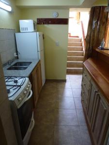 uma cozinha com um fogão e um frigorífico em Cabañas Gnionguis em Villa La Angostura