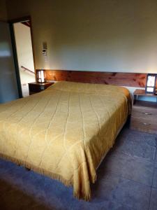 een slaapkamer met een bed, 2 dressoires en een spiegel bij Cabañas Gnionguis in Villa La Angostura