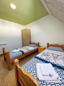 a bedroom with two beds and a green ceiling at Gorštak in Žabljak