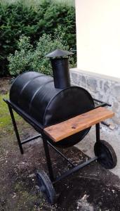a black barbecue grill with a wooden table on wheels at Cabañas Gnionguis in Villa La Angostura
