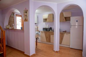 a kitchen with an archway and a white refrigerator at Kamilla Vendégház Borzont in Borzont