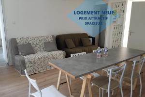 a table and chairs in a living room with a couch at Le Cocon Familial - Dormir Comme A La Maison - in Saint-Julien-de-Vouvantes