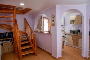 a kitchen with a spiral staircase in a house at Kamilla Vendégház Borzont in Borzont