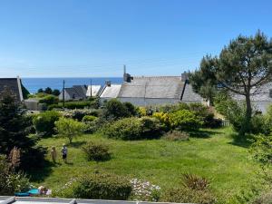 a garden with people standing in the grass at L'air marin in Plozévet