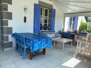 a blue table and chairs on a patio at L'air marin in Plozévet