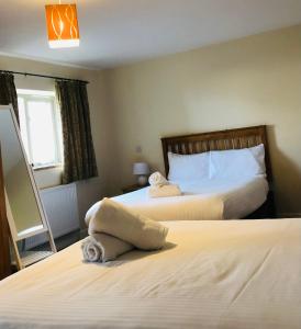 um quarto com 2 camas e toalhas em Canons Court Mews em Wotton under Edge