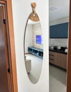 einen Spiegel in der Küche und ein Wohnzimmer in der Unterkunft Itacimirim pé na areia 2Q in Itacimirim