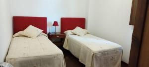 a room with two beds and a table with a lamp at OROEL Beds & Dreams - Espectacular planta baja en Badaguás-Pirineo in Badaguás