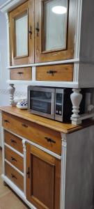 a microwave sitting on top of a wooden cabinet at OROEL Beds & Dreams - Espectacular planta baja en Badaguás-Pirineo in Badaguás