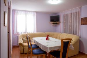 a living room with a table and a couch at Kamilla Vendégház Borzont in Borzont