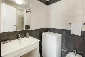 W łazience znajduje się umywalka, toaleta i lustro. w obiekcie White Flat Termini w Rzymie