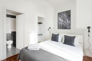 a white bedroom with a large bed and a bathroom at White Flat Termini in Rome