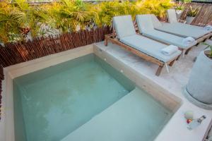 a pool of water with a chair and a chaise lounge at PH-4-Groups 3BR Priv-RoofTop 18Pax @Aldea Zama in Tulum