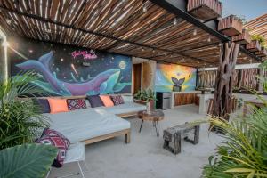 a living room with a bed and a painting on the wall at PH-4-Groups 3BR Priv-RoofTop 18Pax @Aldea Zama in Tulum