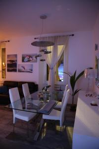 uma sala de jantar com uma mesa de vidro e cadeiras brancas em Alloggio incantevole in trastevere em Roma