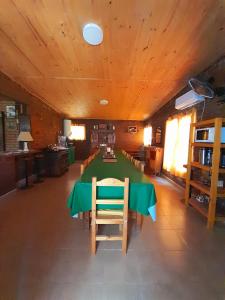 a dining room with a green table and chairs at Estancia San Carlos in Luan Toro