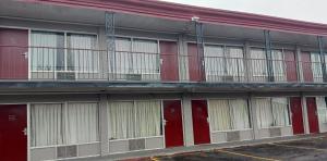 a building with red doors and balconies on it at Red Roof Inn Fort Worth West in Fort Worth