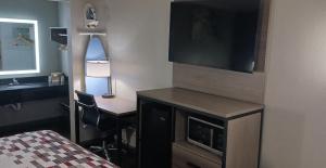 a room with a desk and a television and a bed at Red Roof Inn Fort Worth West in Fort Worth