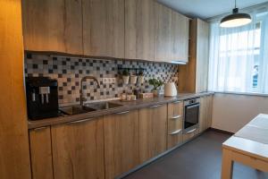 a kitchen with wooden cabinets and a sink at Apartament Ana in Şelimbăr