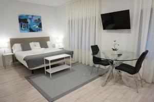 a bedroom with a bed and a glass table at Inés Luna Suites in Salamanca