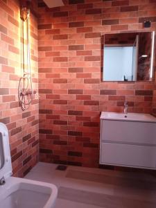 a bathroom with a brick wall and a sink at Résidence Marie France MENDY in Toubab Dialaw