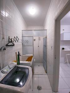 ein Badezimmer mit Waschbecken, Dusche und Badewanne in der Unterkunft APTO na praia Pitangueiras - Guarujá in Guarujá