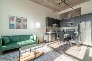 McCormick Place beautiful 2b-2b apartment with optional parking - sleeps up to 6 في شيكاغو: غرفة معيشة مع أريكة خضراء ومطبخ