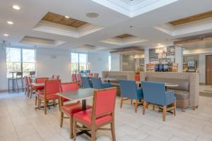 a dining room with colorful chairs and tables at Holiday Inn Express Hotel & Suites Thornburg-S. Fredericksburg by IHG in Thornburg