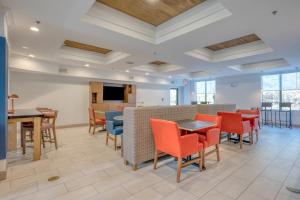 a large room with tables and chairs and a tv at Holiday Inn Express Hotel & Suites Thornburg-S. Fredericksburg, an IHG Hotel in Thornburg