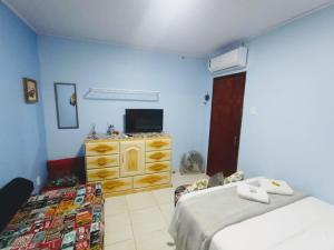 1 Schlafzimmer mit 2 Betten, einem TV und einer Kommode in der Unterkunft Loft IMTur in Praia Sêca