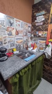 eine Küchentheke mit Spüle und eine Wand mit Schildern in der Unterkunft Loft IMTur in Praia Sêca