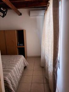 1 dormitorio con cama y ventana en Departamento Zanzin en Mendoza