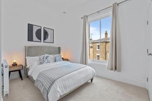 a white bedroom with a bed and a window at Cosy Apartment in the heart of Southampton in Southampton