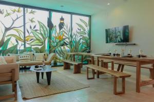 a living room with tables and a mural at PH-4-Groups 3BR Priv-RoofTop 18Pax @Aldea Zama in Tulum