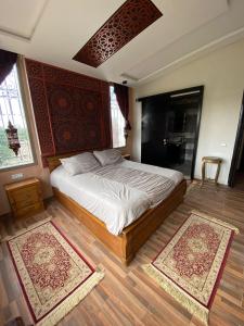 1 dormitorio con 1 cama y 2 alfombras en el suelo en Dar Ghita en campagne, en Benslimane