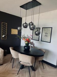 a dining room with a black table and chairs at Apartment Marmoris in Zandvoort