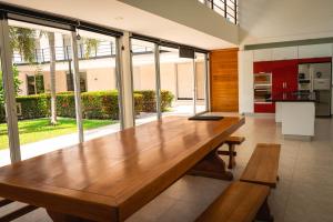 una gran mesa de madera en una habitación con ventanas en Villa California, en Sopetrán
