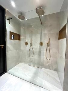 a bathroom with a shower with white tiles at Apartment Marmoris in Zandvoort