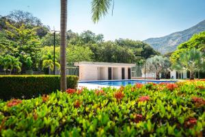 una casa con piscina y algunas flores en Villa California, en Sopetrán