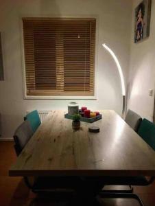 ein Holztisch mit Stühlen in einem Raum mit Fenster in der Unterkunft Heerlijk huis in een prachtige bosrijke omgeving. in Putten