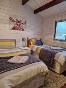 um quarto com duas camas e uma foto na parede em The Log Cabin em Waterford