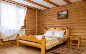 a bedroom with a bed in a log cabin at ВІДЕНЬ in Slavske