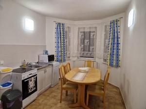 una pequeña cocina con mesa, sillas y fregadero en Appartement in Nitra under the Zobor-Hill, en Nitra